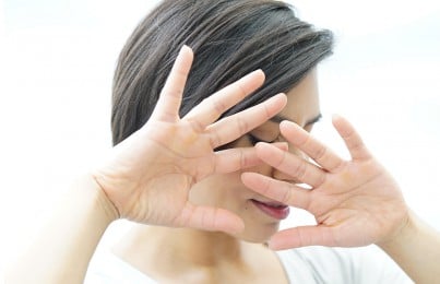 a woman hiding her face with her hands