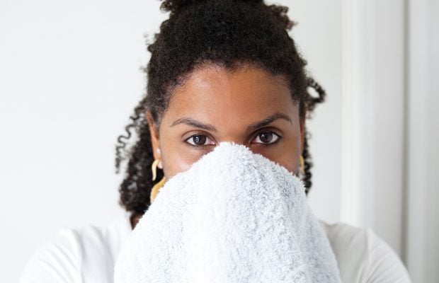 woman drying her face with a towel