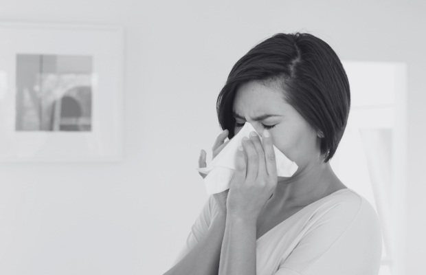 model blowing her nose when sick