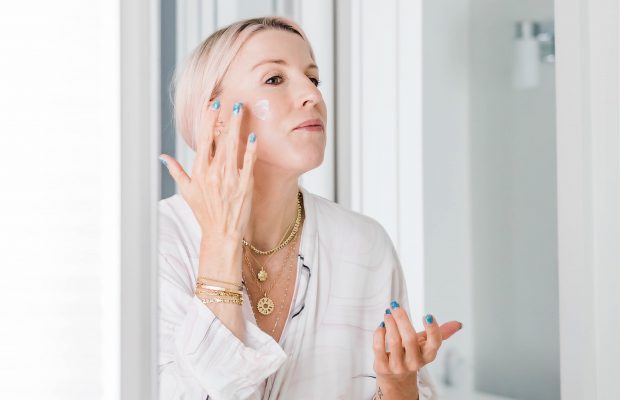 Renee Rouleau applying a retinol skincare product on her face