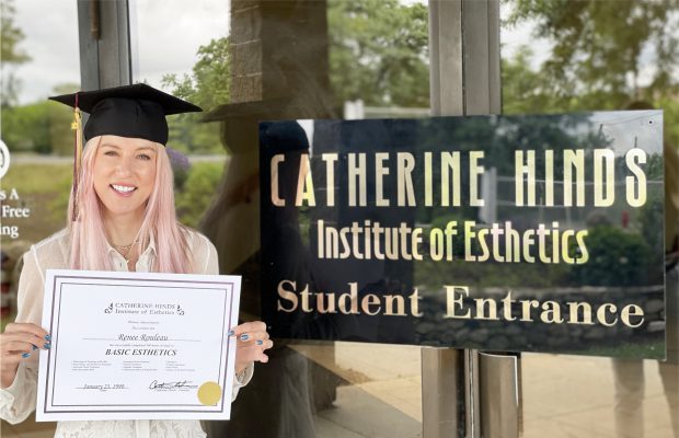 Renée Rouleau in front of Catherine Hinds School with diploma