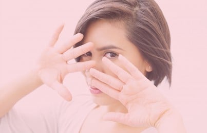 a woman covering her race with her hands