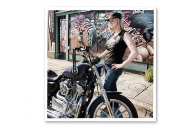 a woman standing with a bike in the street