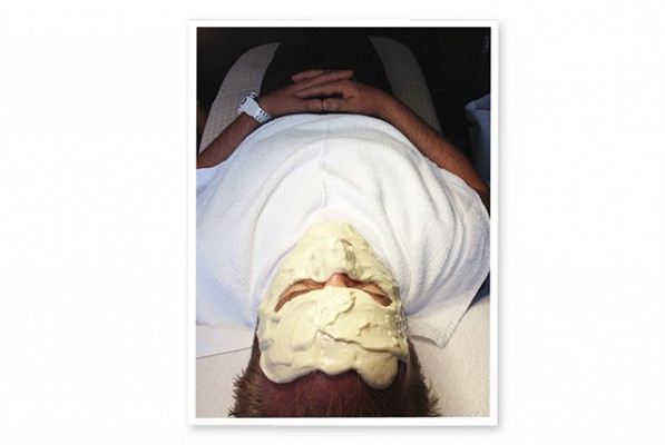 a man laying on a bed with a facemask on