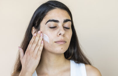 a woman moisturizing her face