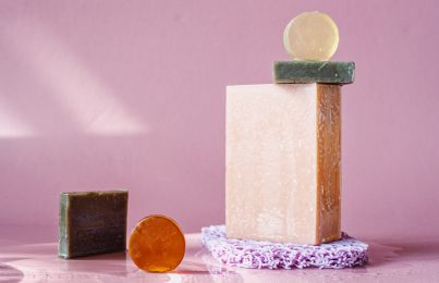 Bars of facial soap stacked on pink background
