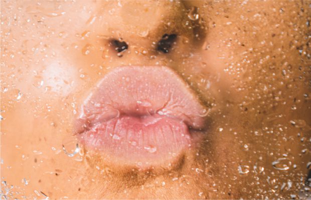Woman kissing glass with lips