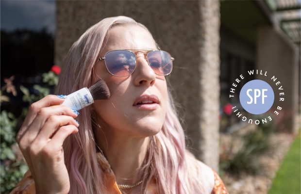woman reapplying sunscreen over makeup using tinted powder