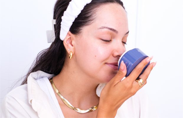 Girl sniffing fragrance in skincare jar