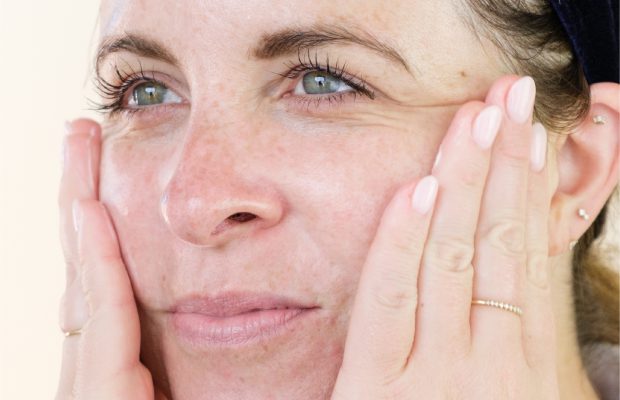 Woman with oily skin touching eye wrinkles